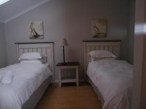 Dos camas una al lado de la otra en un dormitorio. en 75 The Dunes, en Plettenberg Bay