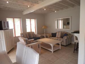 Una sala de estar con dos sillas y una mesa. en 75 The Dunes, en Plettenberg Bay
