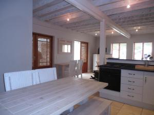 Una cocina con una mesa de madera y un comedor. en 75 The Dunes, en Plettenberg Bay 4 fotos más