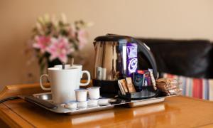 uma bandeja com uma cafeteira e chávenas numa mesa em Adelphi Portrush em Portrush