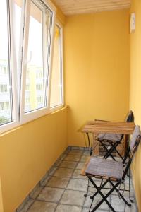een tafel en stoelen in een kamer met 2 ramen bij Near Park Apartment in Druskininkai