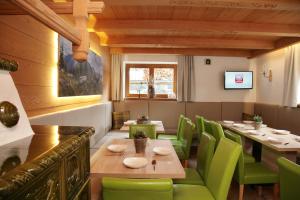 a dining room with a table and green chairs at Andrea in Leogang