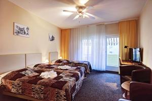 ein Hotelzimmer mit 2 Betten und einem Deckenventilator in der Unterkunft Hotel Kallmeyer in Berlin