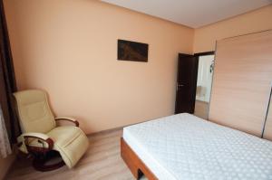 a bedroom with a bed and a chair in it at Prestige apartment in Komárno