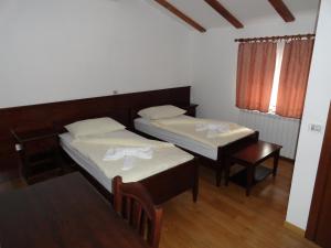 um quarto com 2 camas, uma mesa e uma janela em Guest House Pod Slavnikom em Podgorje