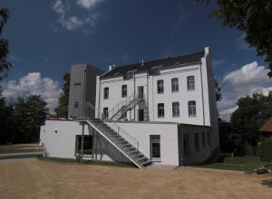 a white building with a staircase on the side of it at Hotel zwischen den Seen in Waren