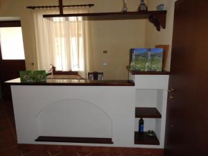 a kitchen with a counter with a fireplace in a room at Guest House Pod Slavnikom in Podgorje