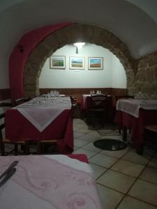 un restaurante con 2 mesas con mantel rojo en SUITE-TTI en Valentano