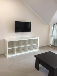 a living room with a tv on a white wall at Квартира в центре in Gelendzhik
