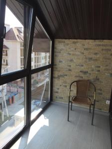 a chair sitting on a balcony next to a brick wall at Квартира в центре in Gelendzhik