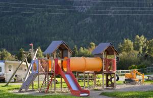 einen Spielplatz mit einer orangenen Rutsche und einer Rutsche in der Unterkunft First Camp Gol Hallingdal in Gol