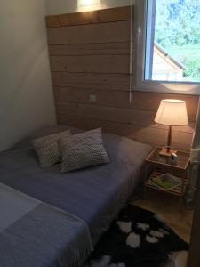 a bed with two pillows and a window in a room at Appartement Les Pics d'Aran in Luchon