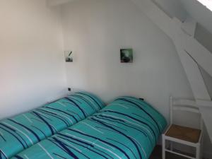 a couch with blue pillows in a room at Le gite des Menhirs in Mont-Saint-Éloi