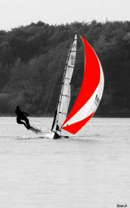 
a man riding a sailboat on top of a body of water at Hotel zwischen den Seen in Waren
