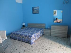 カザラーノにあるAzzurro Cieloの青いベッドルーム(ベッド1台、鏡付)