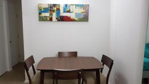 una mesa de comedor con sillas y una pintura en la pared en Perla del Elqui Pacifico, en La Serena