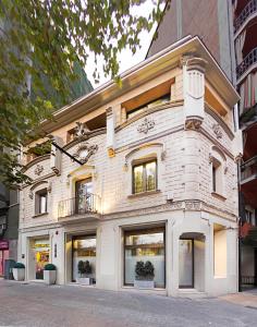 a white brick building with windows on a street at Hostemplo Sagrada Familia in Barcelona