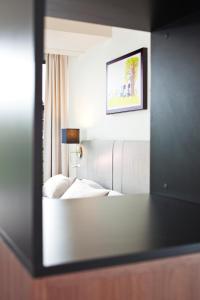 espejo reflejo de una cama en una habitación de hotel en Hapimag Apartments Amsterdam, en Ámsterdam