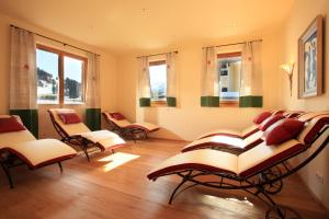 Cette chambre dispose d'un bouquet de chaises et de fenêtres. dans l'établissement Haus Carolin, à Westendorf