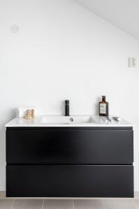 a black bathroom sink with a white counter top at Frogner House - Grünerløkka in Oslo