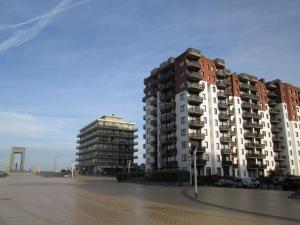two tall apartment buildings in a parking lot at De Panne Plaza in De Panne