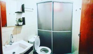 a bathroom with a shower and a toilet and a sink at Pousada Angela in Urubici