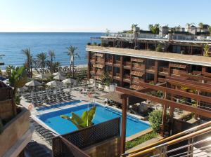 a view of a hotel with a swimming pool and the ocean at Gran Hotel Guadalpín Banus in Marbella