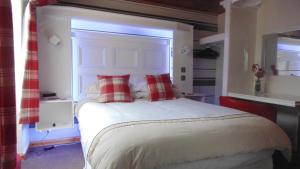 una camera da letto con un grande letto bianco con cuscini rossi di Westmore Bed & Breakfast a Alness