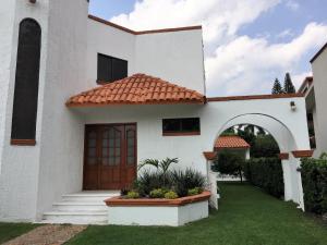 una casa blanca con una puerta marrón y un patio en Lomas de Cocoyoc , Family- Friendly, en Cocoyoc