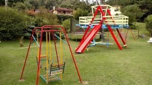 a group of colorful playground equipment in a yard at Tarkna - Hotel Holandês in Teresópolis
