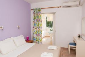 een slaapkamer met een wit bed en een glazen schuifdeur bij Kolios Seaside Apartments in Kolios
