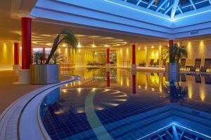 een hotellobby met een zwembad in het midden bij H+ Hotel & SPA Friedrichroda in Friedrichroda