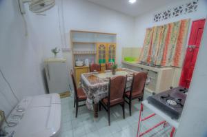 a kitchen with a table and chairs in a kitchen at Budget Umi Homestay Kuching in Kuching