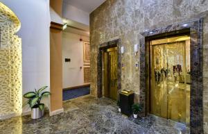 a hallway with two gold doors in a building at Golden Dune Al faihaa in Riyadh +58 photos