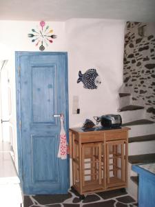 una habitación con una puerta azul y un pez en la pared en 3-level doll house in Kea Ioulida/Chora, Cyclades, en Ioulida