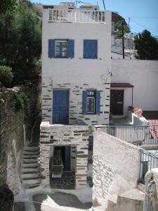 Biały budynek z niebieskimi okiennicami w obiekcie 3-level doll house in Kea Ioulida/Chora, Cyclades w mieście Ioulida