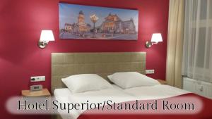 Bett in einem Superior Standard Zimmer mit roten Wänden in der Unterkunft Hotel Vita Berlin-Messe in Berlin