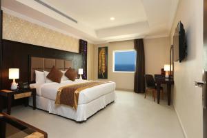 a hotel room with a large bed and a television at Park Jizan Hotel in Jazan