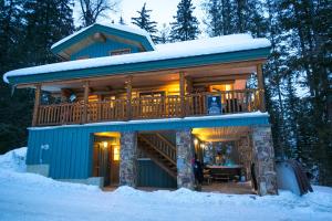 a log cabin in the woods in the snow at Snow Creek Cabins by Fernie Lodging Co in Fernie