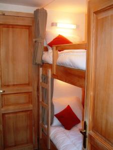 モルジヌにあるChalet Leslieの二段ベッド2台とドアが備わる小さな客室です。
