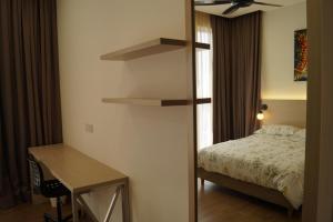 a bedroom with a bed and a desk and a desk at Sentrio Pandan Kuala Lumpur in Kuala Lumpur