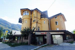 a large yellow building on the side of a street at Tukan Hotel in Krasnaya Polyana