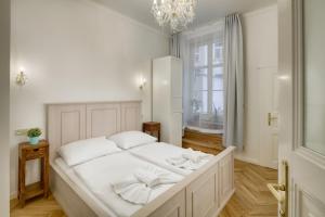 a large white bed in a room with a window at Dušní 13 - Old Town Apartment in Prague