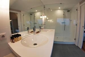 a white bathroom with a sink and a shower at Le Churchill Hôtel & Spa in Carnac