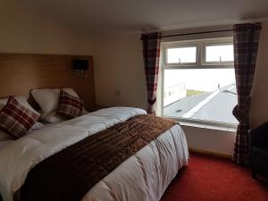 a bedroom with a bed and a large window at The Cliff Top Inn in Bacton