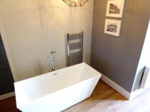 ein Bad mit einer weißen Badewanne in einem Zimmer in der Unterkunft Claremont Apartments, Leeds City Centre in Leeds + 23 Fotos