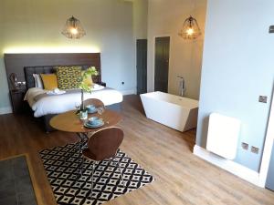 Schlafzimmer mit einem Bett, einer Badewanne und einem Tisch in der Unterkunft Claremont Apartments, Leeds City Centre in Leeds