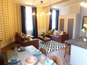 ein Wohnzimmer mit Sofas und ein Esszimmer in der Unterkunft Claremont Apartments, Leeds City Centre in Leeds