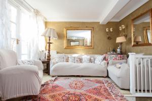 a living room with white couches and a mirror at ItalianFlat - Oakley in London