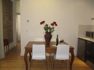 a dining room with a table with a vase of flowers at Life Apartments Alberto Lista in Seville